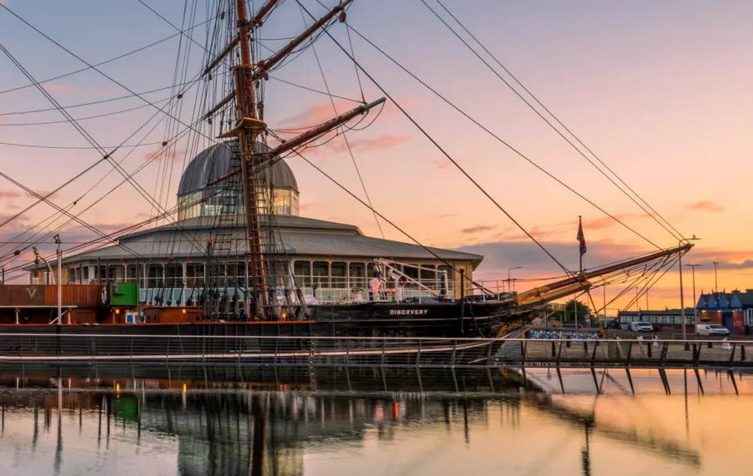 The RSS Discovery docked at sunset
