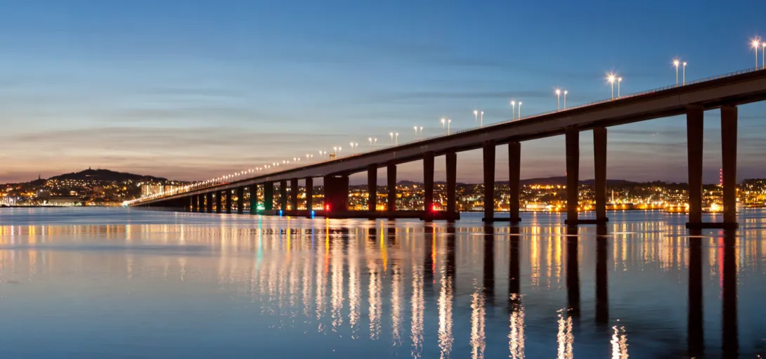 The Tay Bridge at night, lights shimmering on the water