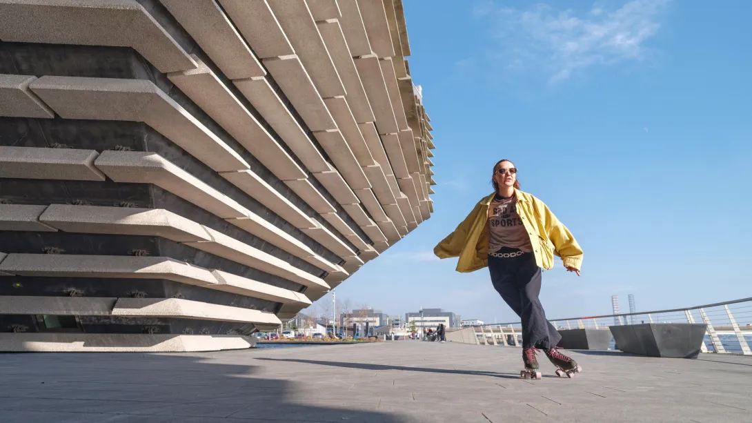 Woman skating past V&A Dundee